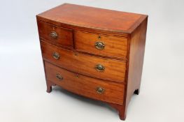 A Regency mahogany crossbanded and ebony strung bowfront chest of two short and two long drawers. On