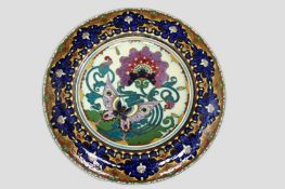 An impressive Dutch Art Nouveau pottery circular wall plaque. Butterfly amidst flowers, elaborate