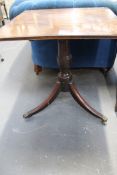 An inlaid Regency tilt top lamp table. Crossbanded top. Urn turned pedestal trifid sabre legs end in