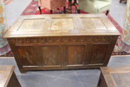 A early oak coffer. Triple panel top above a carved frieze and four panel base. Each panel with five