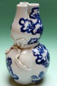 A Chinese blue and white triple gourd shaped vase with flowering peony designs. 22cm high.