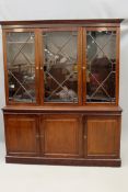 An Edwardian mahogany library bookcase. Moulded cornice over three astragal glazed doors above