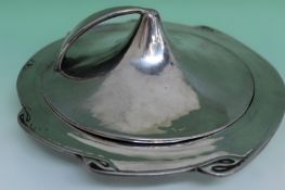 An Arts and Crafts lidded pewter muffin dish. 25cm diameter. 10cm high. Together with a pair of