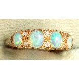 A gold four stone opal set ring with diamond points.