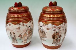 A pair of Japanese Kutani barrel shaped lidded vases with peach finials. Decorated with musicians.