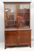 A late Georgian mahogany bookcase with moulded cornice. Two six panel glazed doors with mahogany