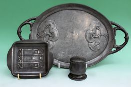 A Tudric pewter pin tray. A shaker. An Art Nouveau pewter two handled tray. 33cm long and a copper