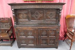 An early oak court cupboard with pilaster supports and carved decorations. 150cm high. 149cm high.