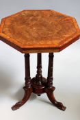 A Victorian walnut occasional table. Octagonal top over triple column supports and triform legs.