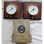 A pair of small 4" diameter brass cased Pressure Gauges mounted side by side on a wooden board. Both