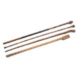 GROUP OF FOUR ASSORTED CANES A group of ethnographic carved or decorated canes, one made of horn