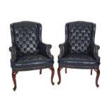 PAIR OF BLUE LEATHER CHAIRS A pair of wingback chairs with blue button-tufted leather upholstery.