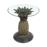 JOAN COLLINS PINEAPPLE TABLE AND POTTERY AND STONE CAMELS A side table with a glass top and carved