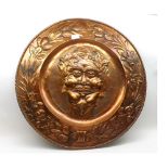 A large Art Nouveau Copper Charger, the centre decorated with the head of Bacchus, the border with