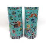 A pair of Chinese cylinder Vases, painted in colours with fish, objects, foliage, etc, 11” high