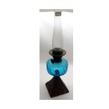 A late 19th Century Oil Lamp with clear glass chimney, blue swirl glass font raised on a cast