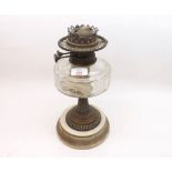 A 19th Century Oil Lamp with brass fittings, clear glass font, brass pedestal and a round ceramic