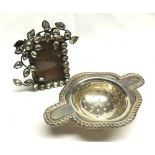 A Mixed Lot comprising: a hallmarked Silver Two-Handled Tea Strainer with gadrooned rim,