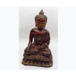 An Oriental Cast Metal Model of a Seated Buddha, decorated in red and gilded lacquer, 15” high