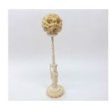 A set of Ivory Concentric Balls on a Figure formed Stand, 7 ¼” high