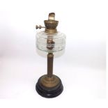 A Victorian Oil Lamp with brass fittings, clear glass font, brass column and a circular metal