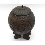 A Carved Siamese Coconut Container with cover, the body decorated all over with various figures,