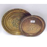 A Mixed Lot: two Middle Eastern Round Copper Trays, decorated with geometric detail, largest 12”