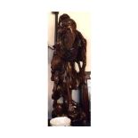 A large Chinese Carved Hardwood Figure of a bearded gent in robes, raised on a pierced plinth