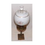 A late 19th/early 20th Century Oil Lamp with clear glass chimney, opaque glass floral decorated