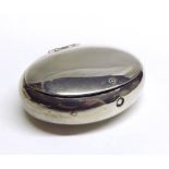 A white metal or plated Tobacco Pebble of oval hinged form, 3” wide, apparently unmarked