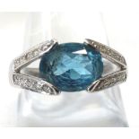 An unusual hallmarked 18ct White Gold Ring featuring an oval mid blue stone within Diamond Set “V