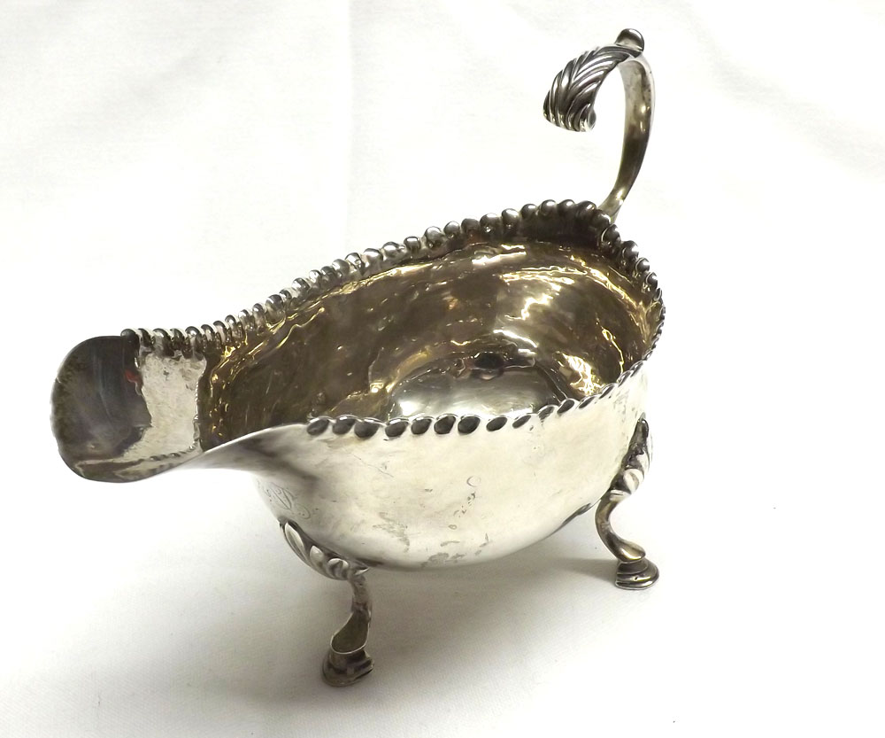 A George III Silver Sauceboat of typical form, with punch beaded rim, leaf capped flying scrolled