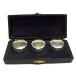 A cased set of three Silver Ointment Jars with screw-on lids, marked I C & B, in a fitted black