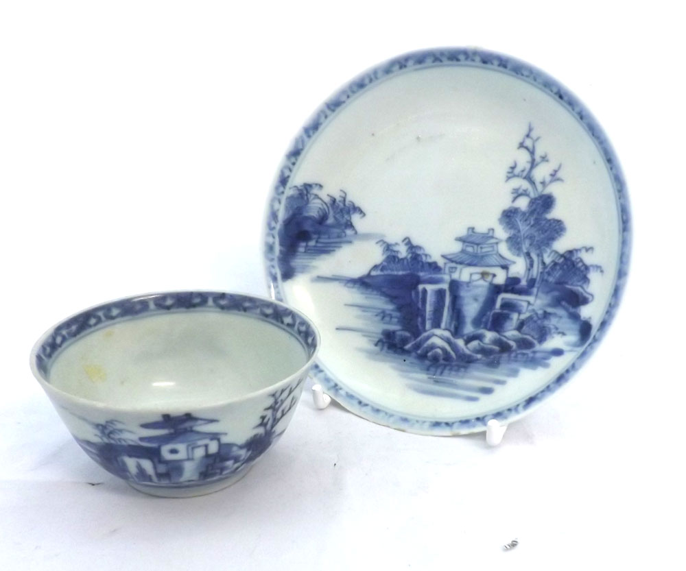 A Nankin Cargo Tea Bowl and Saucer, typically decorated in underglaze blue with Chinese river scene,