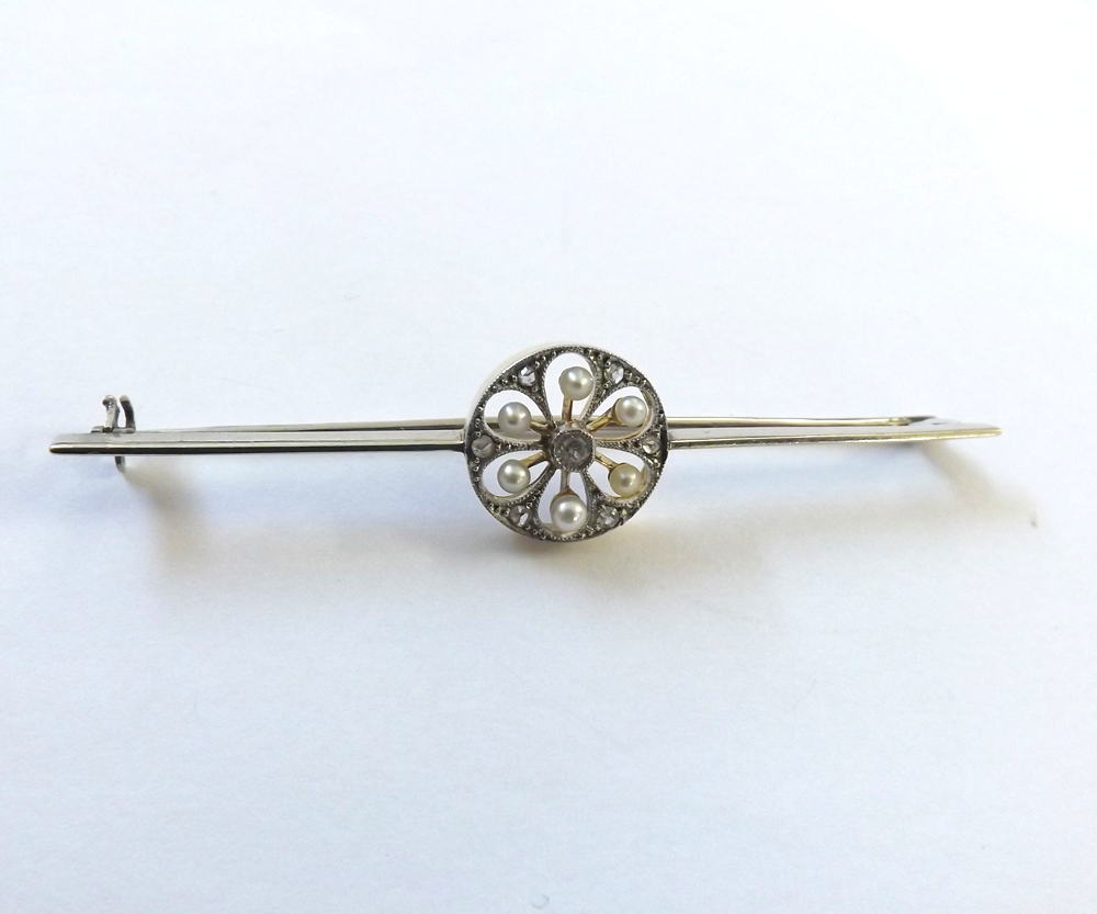 An Art Deco designed precious metal Bar Brooch, a centre circular panel pierced and set with six