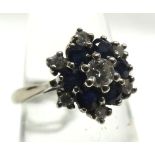 A high grade precious metal ring set with six small dark blue Sapphires and seven small Brilliant