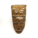 A pale Hardwood large Tribal Mask, the forehead carved with heads of Maidens; together with two