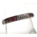 A high grade precious metal half eternity ring set with six square cut Rubies and five Brilliant Cut