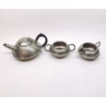 Early 20th Century British hammered Pewter Tea Service, of squat form, comprising Tea Pot, Sugar