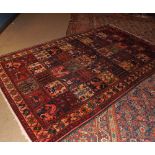 Caucasian carpet double gulled border, central panel of figure and geometric designs etc, mainly red