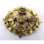 Victorian unmarked yellow metal oval brooch, the centre set with five Citrine/Amber type stones with