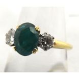 Hallmarked 18ct Gold centre oval Emerald and two brilliant cut Diamond ring, the Emerald measuring