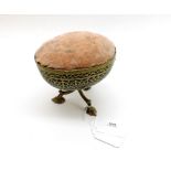 An unusual Novelty Pin Cushion, the oval brass body with fabric top, raised on a tripod base, 4