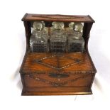 Early 20th Century table top three-bottle Tantalus with integral sub-divided storage section and