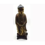 Large Chinese or Tibetan gilt painted treen figure of priest wearing ceremonial robes, further red