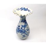 Oriental Vase of tulip baluster form with a crimped rim, decorated in underglaze blue with flowering