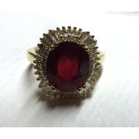 A mid-grade precious metal centre Ruby (5 .40ct) and Diamond surround Cluster Ring, the baguette and