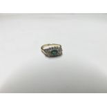 Hallmarked 9ct Gold Ring featuring a centre oval Emerald surrounded by small Brilliant Cut Diamonds