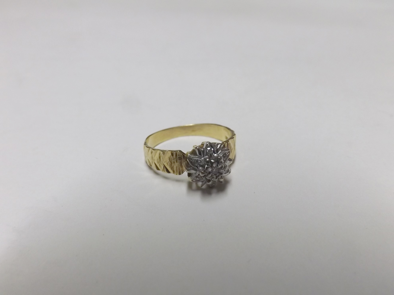 A high grade precious metal all small diamond set cluster Ring of flower head design, having chevron