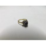 Hallmarked 18ct Gold cluster Ring featuring a centre circular dark blue small Sapphire surrounded by